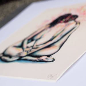 May include: A print of a seated figure, rendered in a soft, blurred style. The artwork features a palette of blues, pinks, and yellows, with the figure's form subtly defined. The print is on a cream-colored paper, with a signature in the lower right corner.
