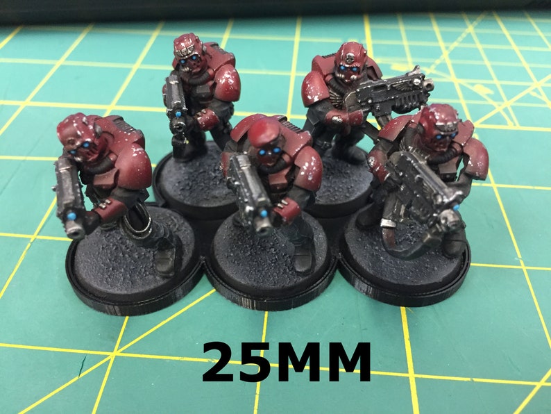May include: Five red and black painted miniature figures with blue eyes, holding guns, standing on 25mm black bases.
