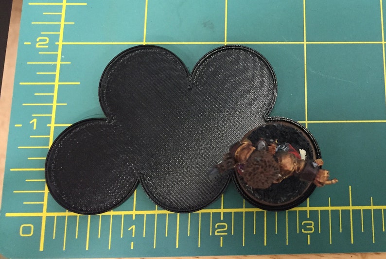 May include: Black 3D printed base with a five-pointed star shape. The base is approximately 2 inches in diameter.