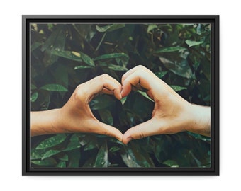 Hands Form A Heart Shape Against Green Leave  Matte Canvas, Black Frame