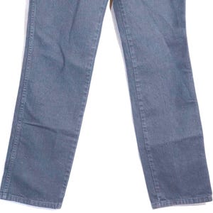 May include: A pair of faded blue jeans. The jeans have a classic five-pocket design, with a straight leg cut. The denim appears to be pre-worn, with subtle fading and wear marks. The jeans are a versatile wardrobe staple.