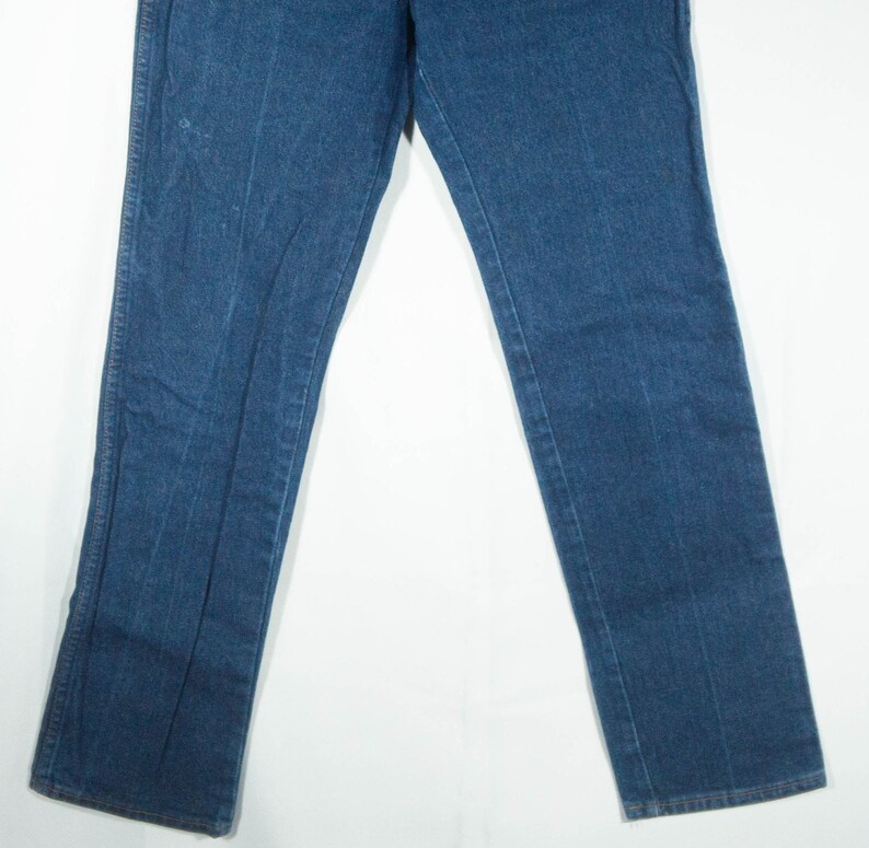 May include: A pair of blue denim jeans. The jeans have a classic five-pocket design, a straight leg, and a medium wash. The jeans are made of a durable denim fabric and are suitable for everyday wear.
