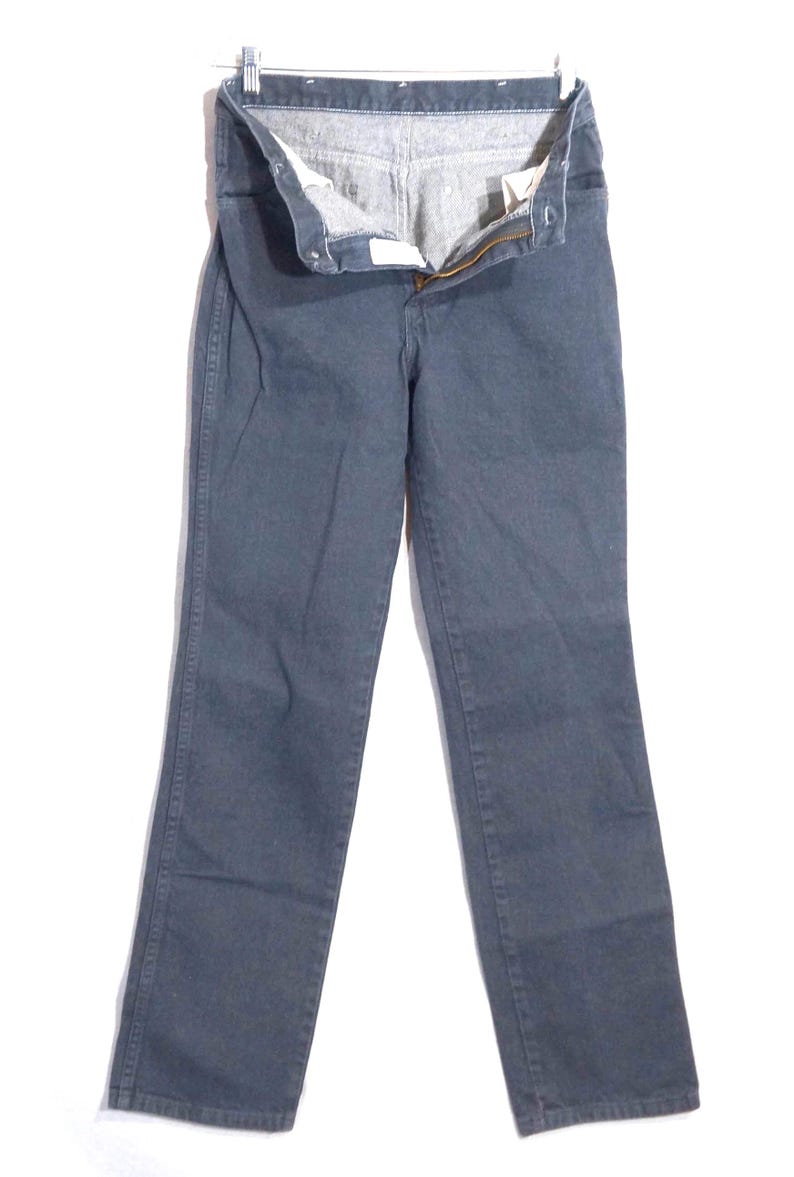 May include: A pair of dark gray denim jeans, displayed on a hanger. The jeans have a classic five-pocket design, a zipper fly, and a button closure. The fabric appears to be a medium-weight denim.