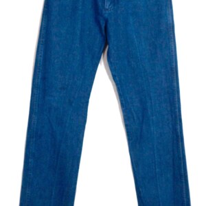 May include: A pair of blue denim jeans with a straight leg. The jeans have a classic five-pocket design, a button and zip fly, and copper-coloured rivets. The denim has a medium wash and a slight fade, giving them a vintage appearance.