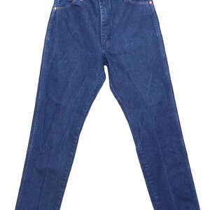 May include: Dark blue denim jeans with a classic five-pocket design. The jeans have a button and zip closure, and are hanging on a white hanger. The jeans are a straight-leg style.