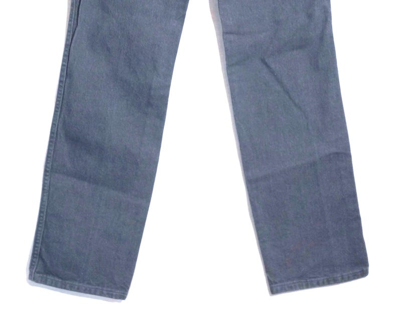 May include: A pair of gray denim jeans. The jeans have a classic five-pocket design, with a straight leg cut. The fabric appears to be a medium-weight denim, suitable for everyday wear. The jeans are displayed against a white background.