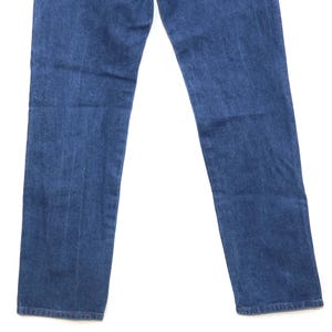 May include: A pair of blue denim jeans. The jeans have a classic five-pocket design and a straight leg cut. The denim has a medium wash with subtle fading and wear marks.