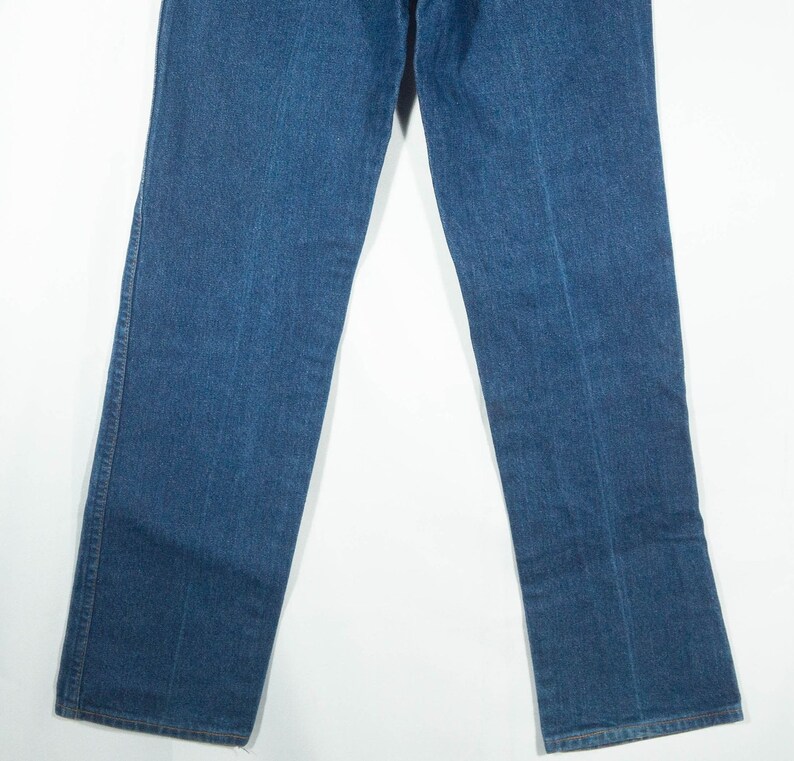 May include: A pair of blue denim jeans. The jeans have a classic five-pocket design, with a straight leg cut. The denim is a medium wash, and the jeans appear to be new or in excellent condition. The jeans are displayed against a white background.