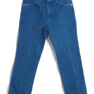 May include: A pair of blue denim jeans with a classic five-pocket design. The jeans have a straight leg cut and are hanging against a white background. The jeans have a button and zip closure, and copper-coloured rivets.
