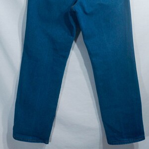 May include: A pair of blue denim jeans. The jeans have a classic five-pocket design and a straight leg fit. The denim is a medium wash, and the jeans appear to be new or in excellent condition.