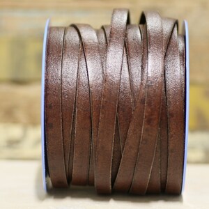 May include: A spool of brown leather cord, wound tightly and ready for crafting projects.