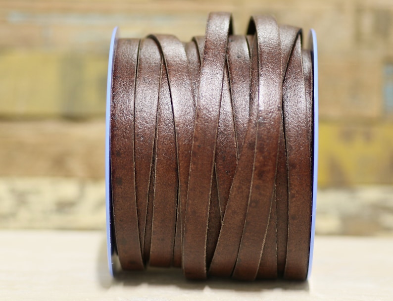 May include: A spool of brown leather cord, wound tightly and ready for crafting projects.