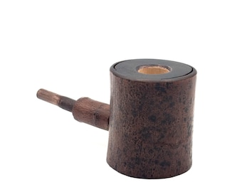 May include: A handcrafted, rustic-style pipe made of dark brown wood. The pipe features a cylindrical bowl with a dark rim and a wooden stem extending from the side. The bowl has a diameter of approximately 1.5 inches.