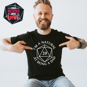 May include: A black t-shirt with a white graphic of a twenty-sided die with the text "I'm a natural at being a dad".