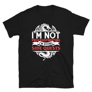 May include: Black t-shirt with a white dragon graphic and the text "I'm not procrastinating I'm doing side quests".