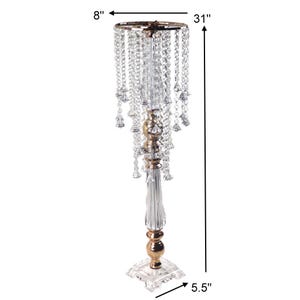 Puede incluir: Un soporte alto para centro de mesa en acr&iacute;lico dorado y transparente con cuentas colgantes tipo cristal. El soporte mide 78,74 cm de altura, 20,32 cm de di&aacute;metro en la parte superior y 13,97 cm en la base cuadrada, con una columna central estriada.
