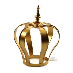 May include: A gold metal crown with a pointed top. The crown is made of thin metal and has a hollow center.