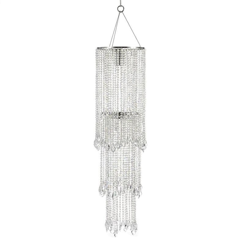May include: A tiered cylindrical chandelier featuring multiple strands of clear, faceted crystal beads suspended from a circular silver-toned metal frame. The fixture hangs from thin wires attached to a central ring, creating a cascading effect.