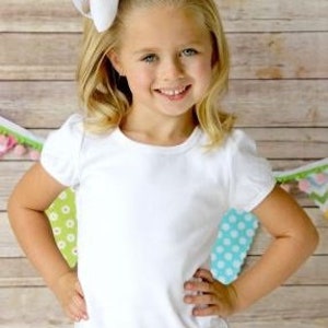 Peut inclure: T-shirt blanche &agrave; manches courtes avec un design simple et classique. Le t-shirt est fait d'un tissu doux et confortable et a une coupe d&eacute;contract&eacute;e.  Girls Regular Short Sleeve (No Ruffles)