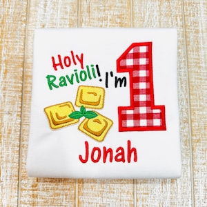 May include: White onesie with red and green embroidery. The embroidery says "Holy Ravioli! I'm 1 Jonah".