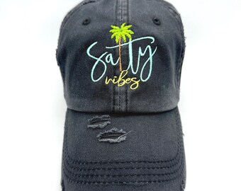 May include: Black distressed baseball cap with the text "Salty Vibes" and a palm tree graphic embroidered on the front.