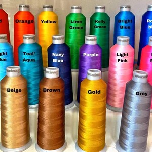May include: A collection of colorful spools of thread, each labeled with a different color name. Colors include red, orange, yellow, green, blue, pink, and more. The spools are arranged in rows, showcasing a wide variety of shades.