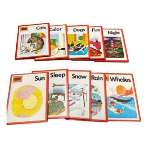 May include: A collection of vintage children's books with red borders. Titles include "Cats," "Color," "Dogs," "Fire," "Night," "Sun," "Sleep," "Snow," "Rain," and "Whales." Each book features colorful illustrations on the cover.