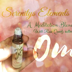 May include: A small, brown glass roller bottle labeled "Om" with the text "Serenitys Elements" and "A Meditation Blend With Rose Quartz roller." The bottle is held in a hand against a soft, pink background.