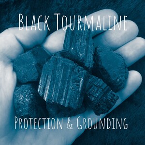 May include: A handful of rough, black tourmaline stones. The image has the text "Black Tourmaline" and "Protection & Grounding" in white, set against a blue-toned background. The stones appear to be raw and natural.