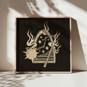 May include: A framed art print featuring a gold-colored illustration on a black background. The design includes a mace, flames, stars, and a staircase. The artwork is displayed in a light-colored wooden frame, creating a striking contrast.