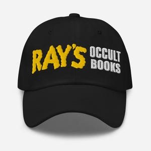 Könnte beinhalten: Schwarze Baseballkappe mit gelbsticktem Text "RAY'S OCCULT BOOKS".