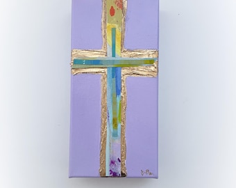 May include: A purple canvas painting with a gold cross in the center. The cross is made of gold leaf and has a variety of colorful stripes and details. The painting is signed "S-P" in the bottom right corner.