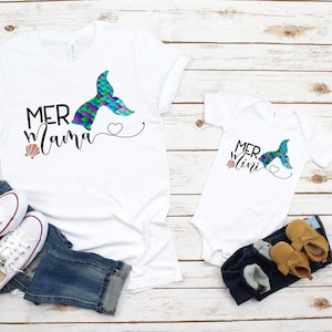 May include: White t-shirts with a mermaid tail graphic and the text "Mer Mama" and "Mer Mini".