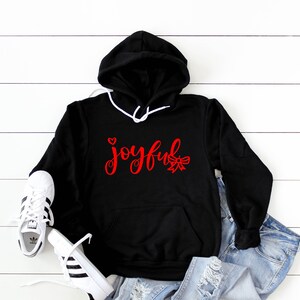 May include: Black hooded sweatshirt with a red graphic that says "joyful" with a small heart and a bow.