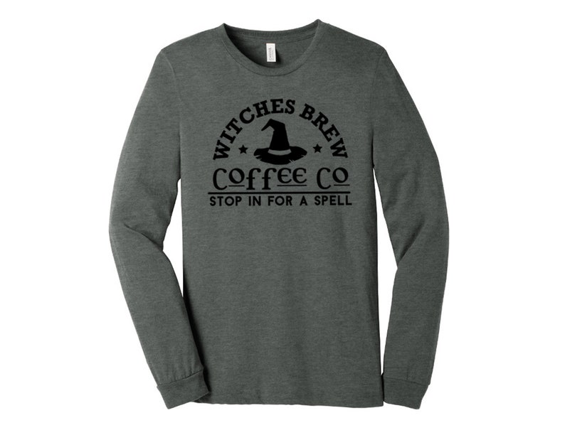May include: A dark heather grey long-sleeve t-shirt with a black graphic of a witch's hat and the text "Witches Brew Coffee Co. Stop in for a spell."