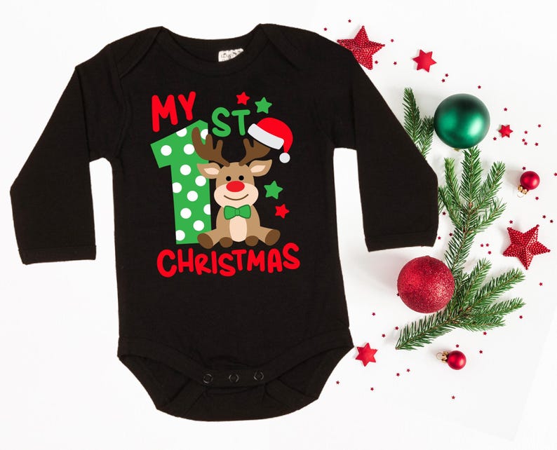 Op de afbeelding: Zwarte romper met lange mouwen met een groene en rode rendierprint en de tekst "My 1st Christmas".