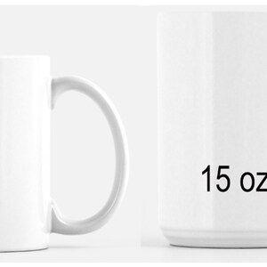 May include: Two white ceramic mugs with curved handles. The smaller mug is labeled "11 oz", and the larger mug is labeled "15 oz". Both mugs are empty and have a glossy finish. The mugs are designed for beverages.
