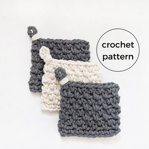 May include: Three crocheted pot holders in different sizes. The largest is gray, the middle is cream, and the smallest is cream. All three have a loop at the top for hanging.