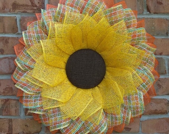 Gran corona de girasoles, decoración otoñal amarilla y naranja para la puerta principal.
