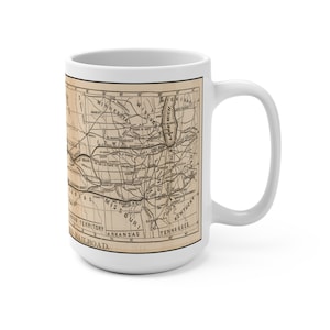 May include: White ceramic mug featuring a vintage map design. The map is in sepia tones and shows the central United States with state names and railroad lines. The mug has a large handle and a glossy finish.