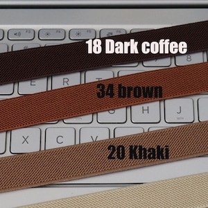 May include: Four different colored elastic bands laid out on a laptop keyboard. The bands are labeled with numbers and colors: 18 Dark coffee, 34 brown, 20 Khaki.