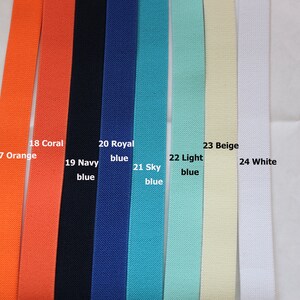 May include: A close-up of eight different coloured fabric straps. The straps are labelled with numbers and colours, including orange, coral, navy blue, royal blue, sky blue, light blue, beige, and white.