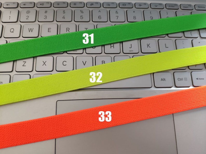 May include: Three elastic bands of different colors: green, yellow, and orange. The bands are labeled with the numbers 31, 32, and 33.