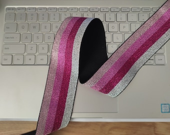 May include: Pink, silver, and white striped elastic trim with a black elastic backing.