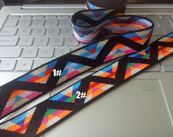 May include: Two black elastic bands with colorful geometric patterns. The bands are labeled "1#" and "2#" and are shown on a silver laptop keyboard.
