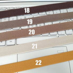 May include: Five different colors of elastic webbing, labeled 18, 19, 20, 21, and 22. The webbing is laid out on a white laptop keyboard.