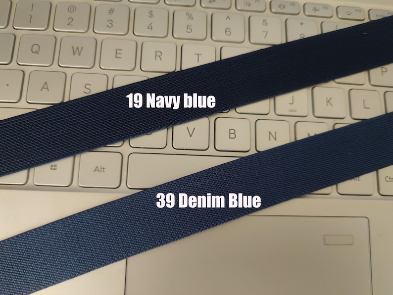 May include: Two fabric straps, one navy blue and one denim blue, are laid out on a white keyboard. The navy blue strap has the text "19 Navy blue" printed on it. The denim blue strap has the text "39 Denim Blue" printed on it.