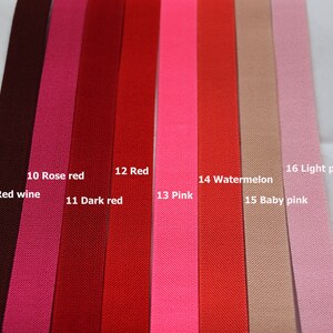 May include: A close-up of 10 different colours of ribbon, including red wine, rose red, dark red, red, pink, watermelon, baby pink, and light pink. The ribbon is arranged in a row from left to right, with the colours getting lighter as they go from left to right.