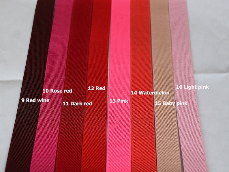 May include: A close-up of 10 different colours of ribbon, including red wine, rose red, dark red, red, pink, watermelon, baby pink, and light pink. The ribbon is arranged in a row from left to right, with the colours getting lighter as they go from left to right.