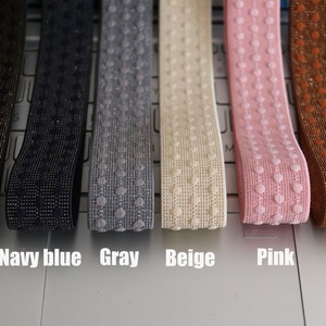 May include: Six different colours of elastic with a dotted pattern. The colours are black, navy blue, grey, beige, pink, and brown.